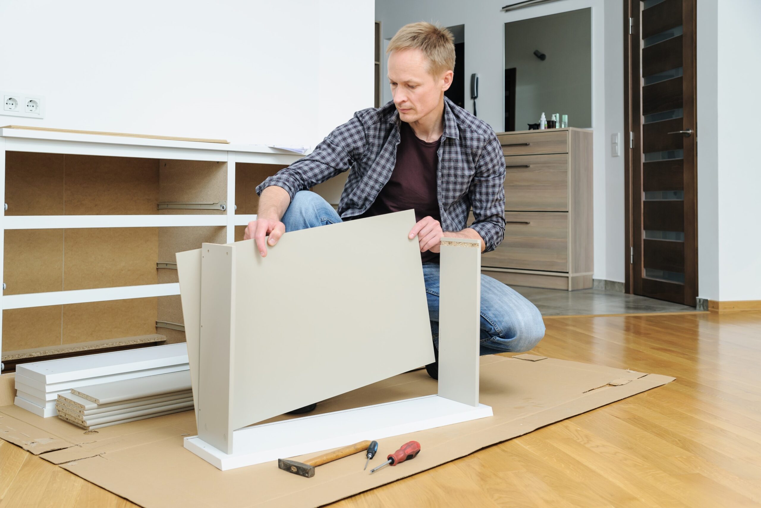 man assembling drawers at home scaled